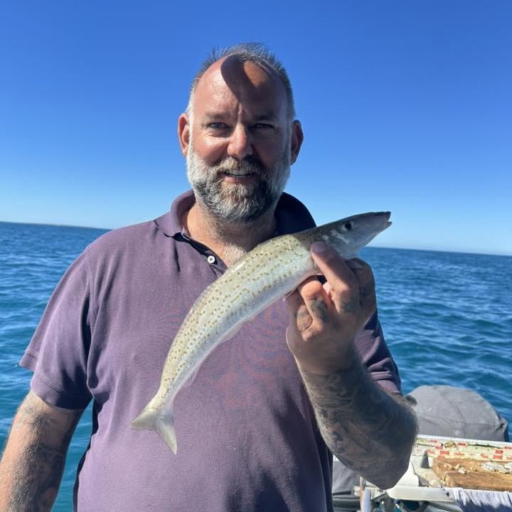 An angler holding up a King George Whiting