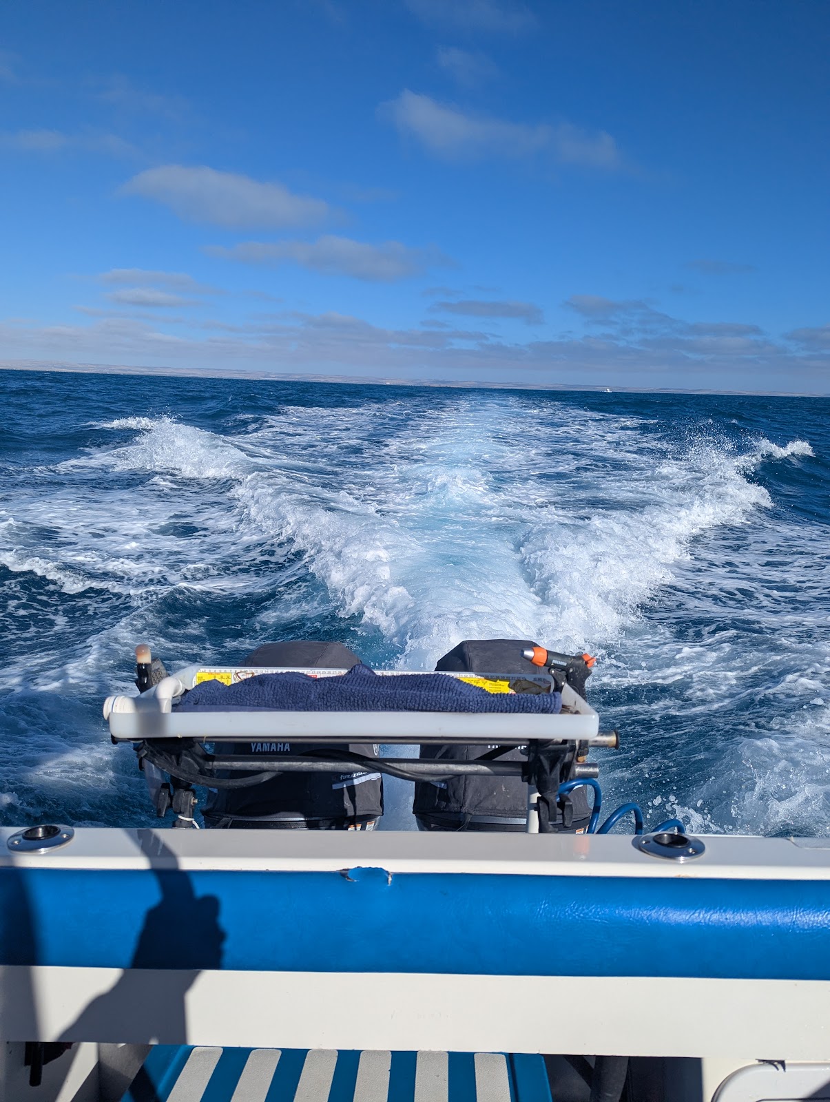 The boat's wake stretching out behind it on open water